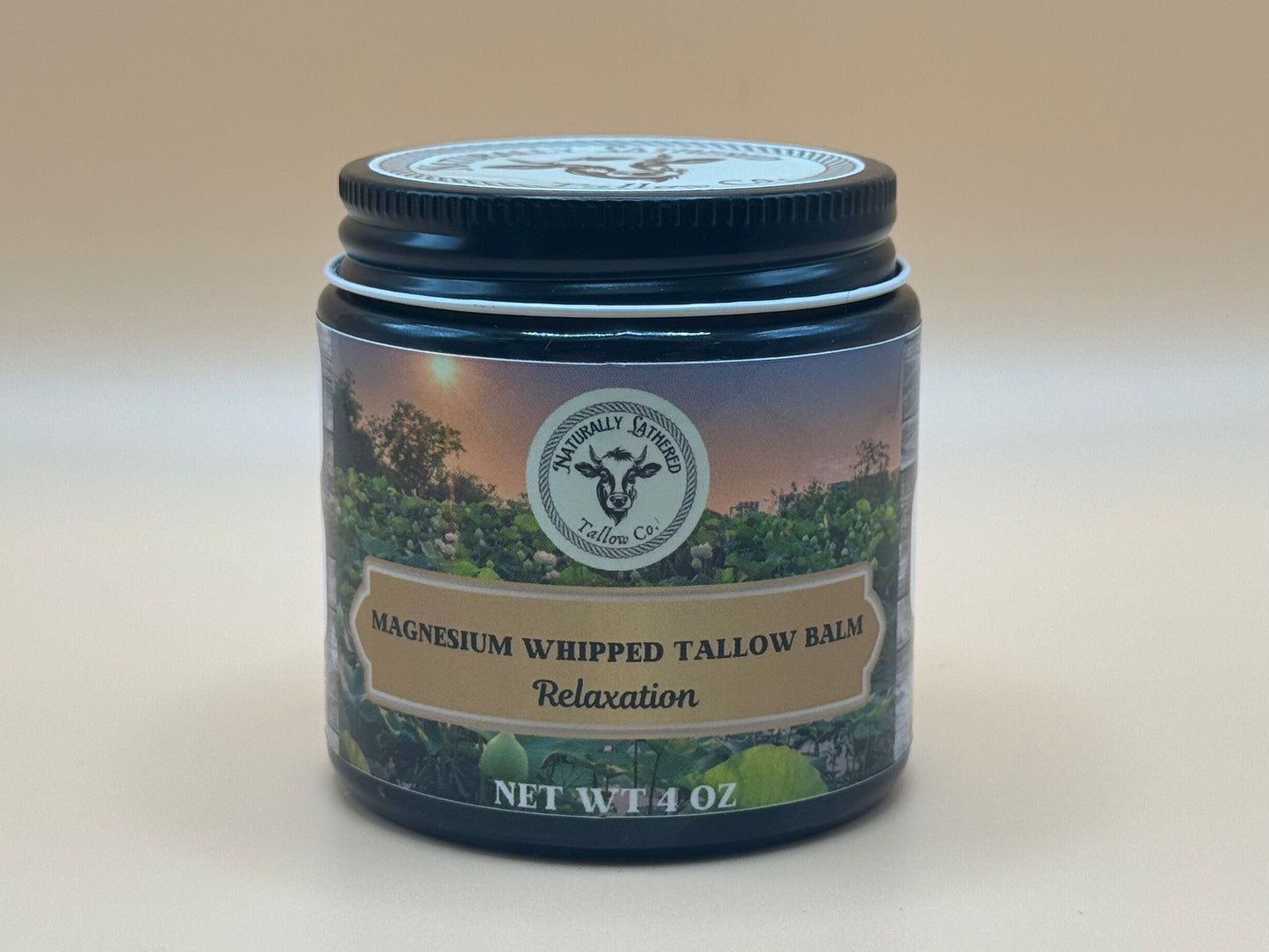 Jar of magnesium whipped tallow balm with a label on a beige background